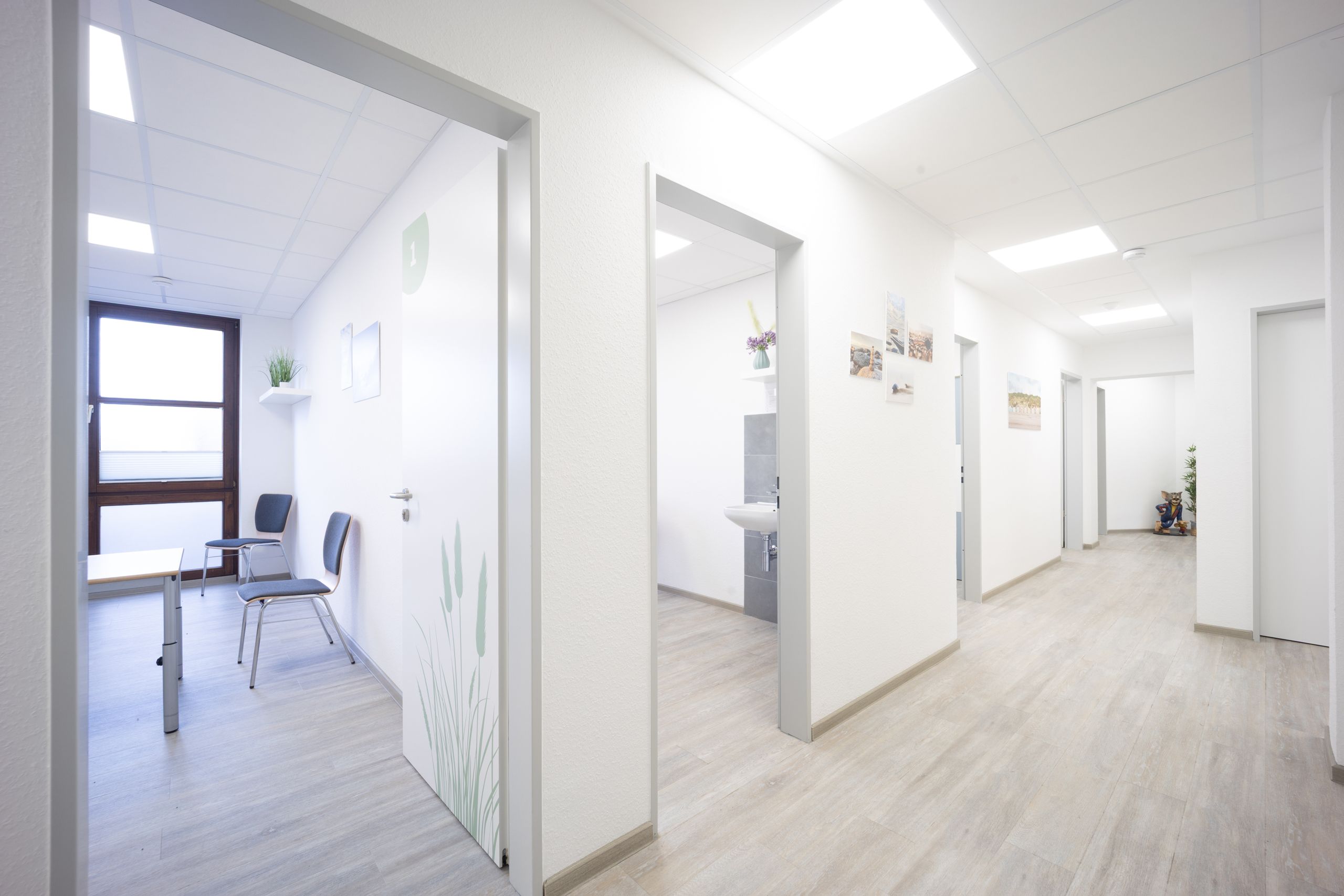 Blick in den Flur mit den Therapieräumen Strandhafer (01), Wellen (02) und Steine (04)