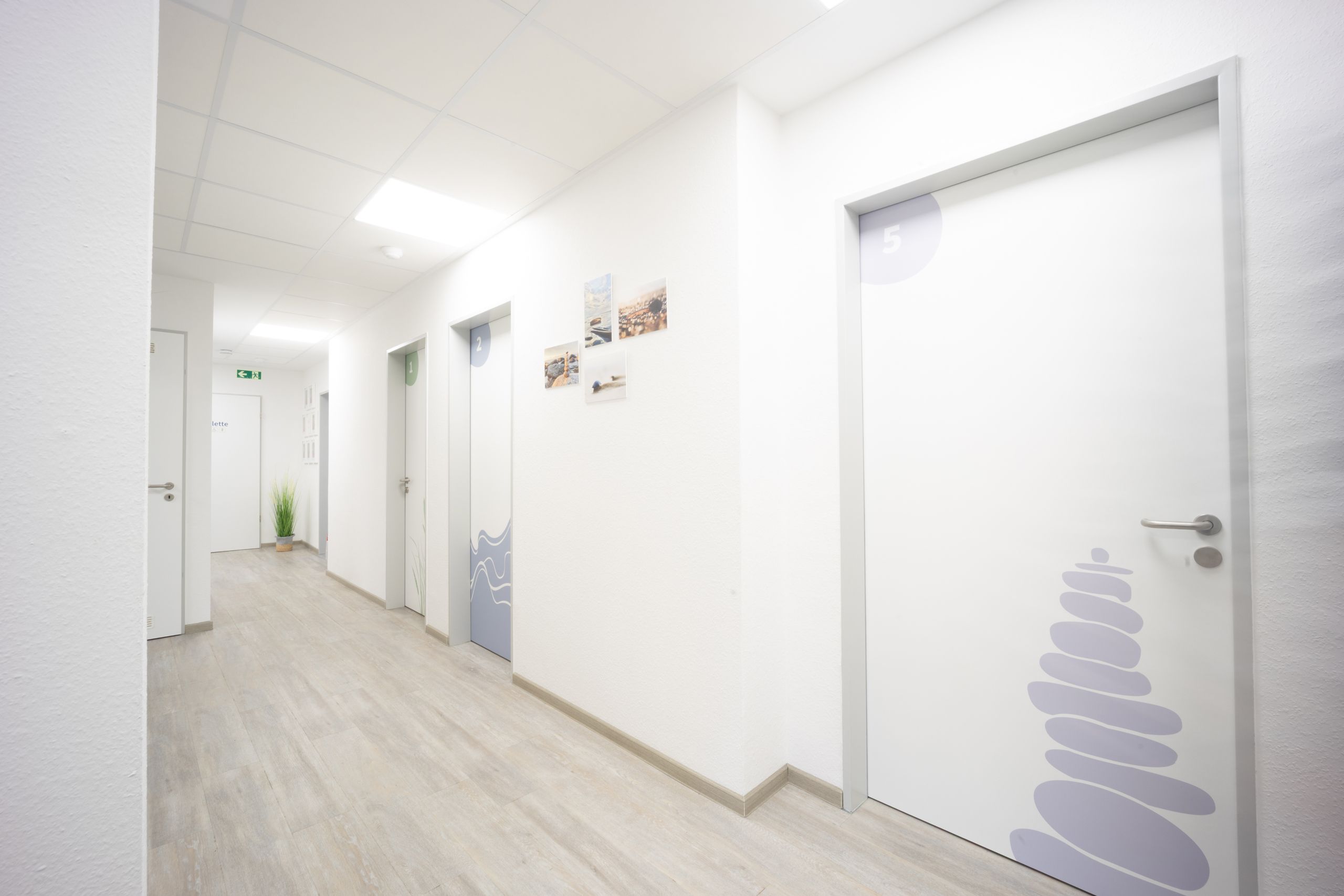 Blick in den Flur mit den Therapieräumen Strandhafer (01), Wellen (02) und Steine (04)