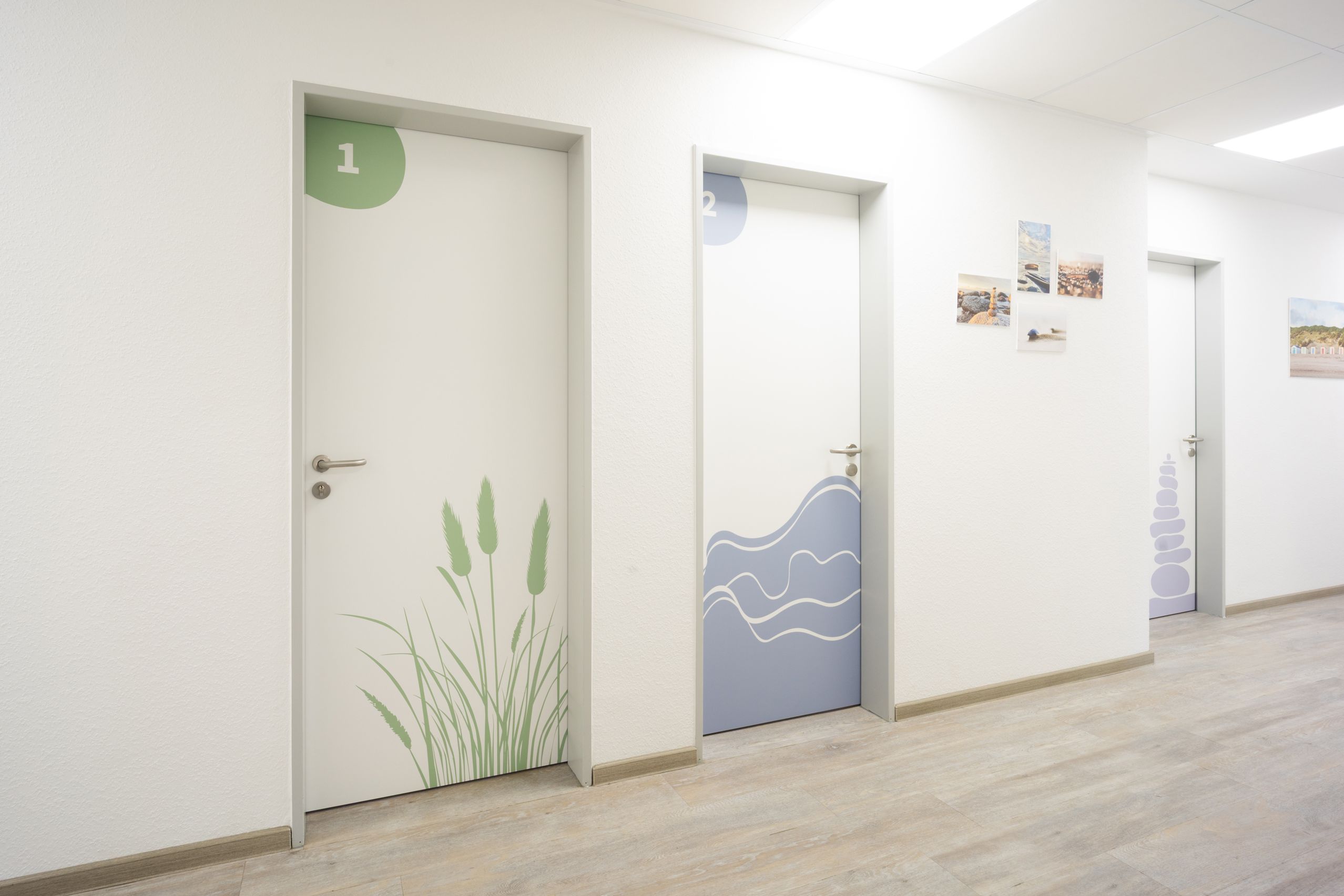 Blick in den Flur mit den Therapieräumen Strandhafer (01), Wellen (02) und Steine (04)