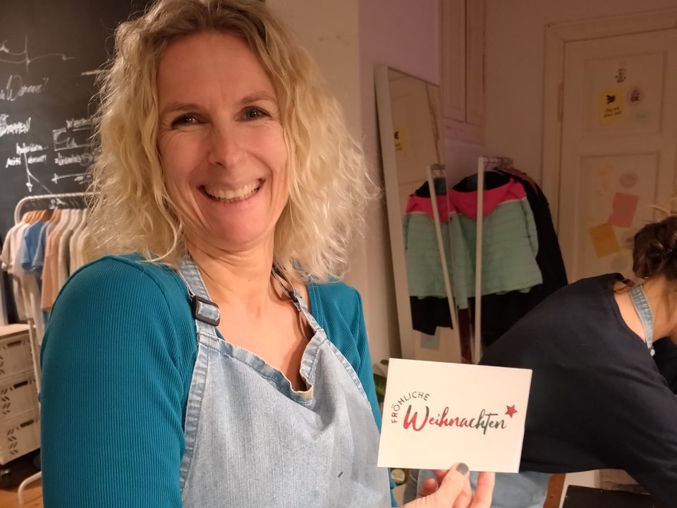 Caro mit gedruckter Postkarte auf der Weihnachtsfeier